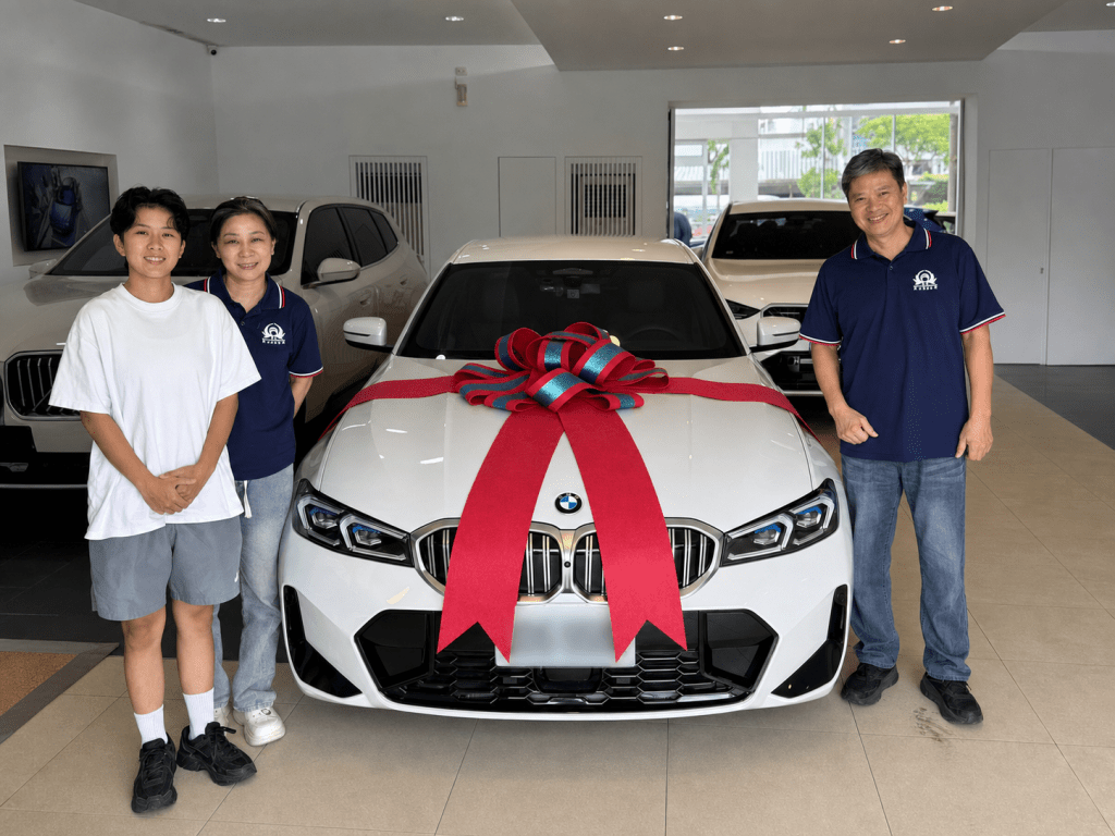**替代文字：** 原本考慮BMW X3的一家三口，試乘比較後改選珍珠白BMW 318i的交車照