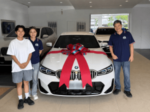 **替代文字：** 原本考慮BMW X3的一家三口，試乘比較後改選珍珠白BMW 318i的交車照